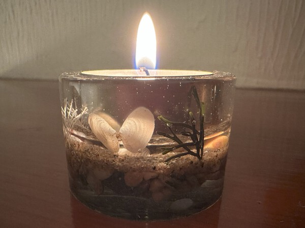Tea light holder, round, with lit candle